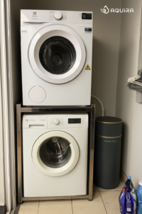 Thiết bị lọc nước tổng đầu nguồn Aquira đặt cạnh máy giặt trong căn hộ chung cư.